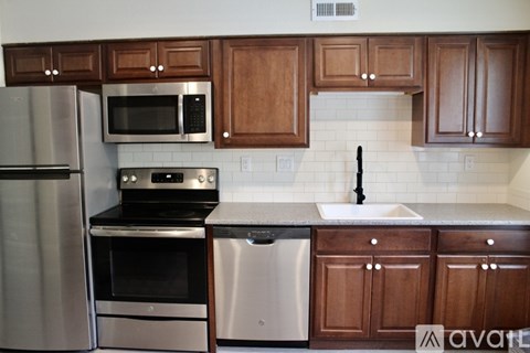 A kitchen with wooden cabinets and stainless steel appliances.