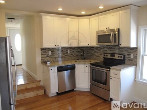 A kitchen with white cabinets and stainless steel appliances.