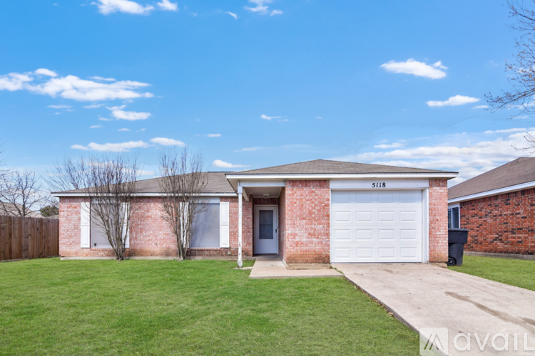 A house with a white garage door and a brown fence.
