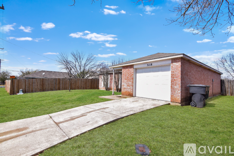 A residential garage with a white door and a brick wall.