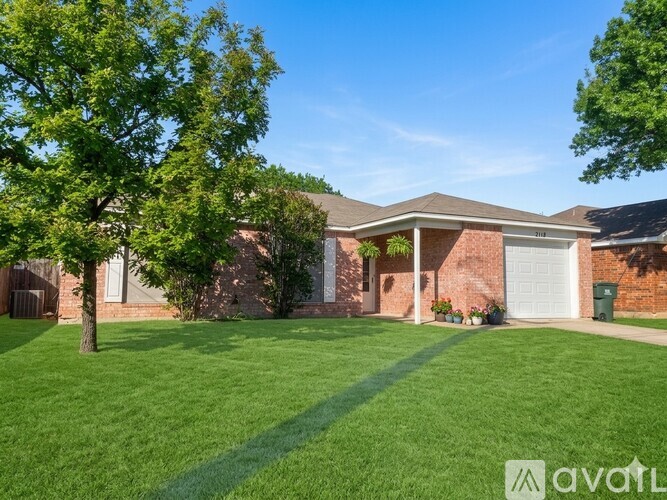 A house with a bare tree in front of it.