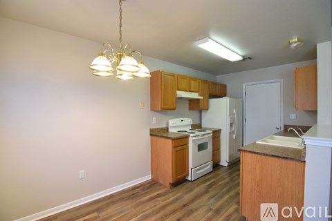 A kitchen with wooden cabinets and a white refrigerator.