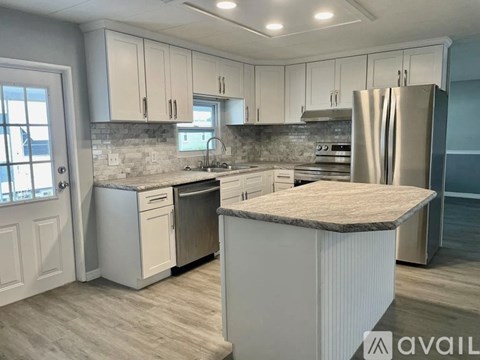 A kitchen with white cabinets and a granite countertop.