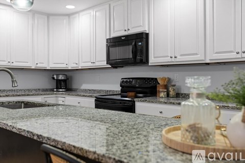 A kitchen with white cabinets and a granite countertop.