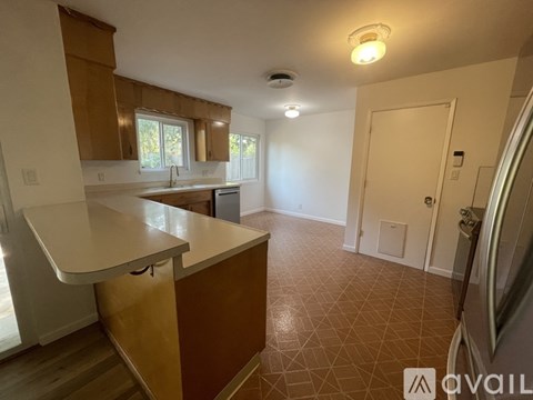 A kitchen with brown cabinets and a white countertop.