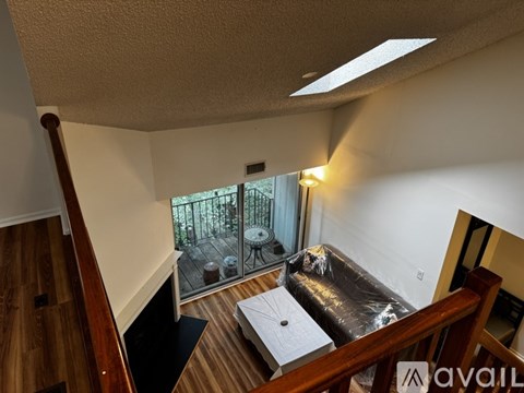 A balcony with a table and chairs is visible from the living room.