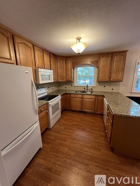 A kitchen with wooden cabinets and a white refrigerator.