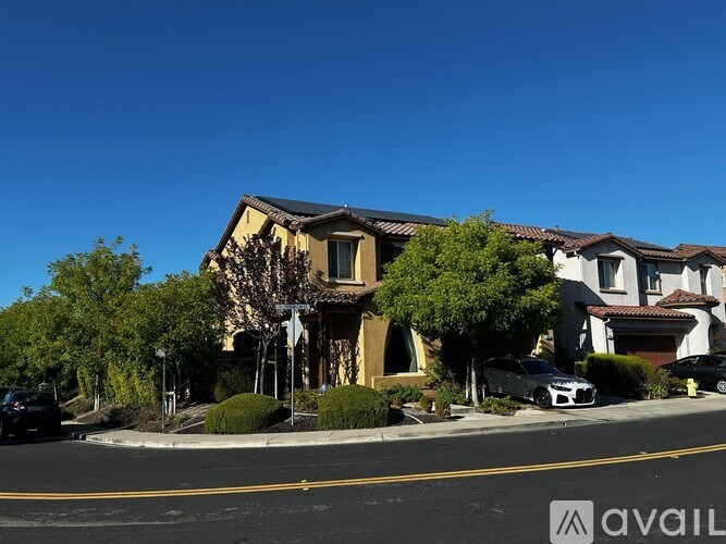 A row of houses with cars parked in front.