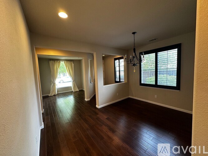 A room with wooden floors and a chandelier.