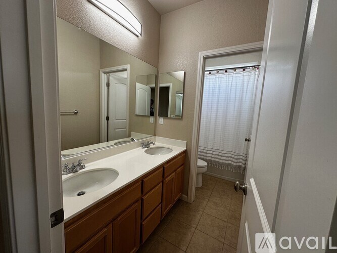 A bathroom with a vanity, mirror, and a shower.