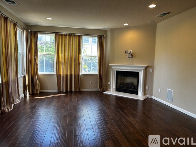 A spacious living room with a fireplace and hardwood floors.