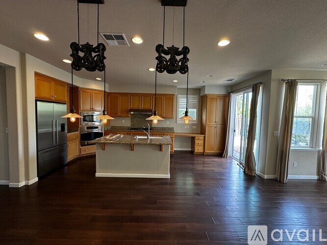 A modern kitchen with wooden floors and a large island.