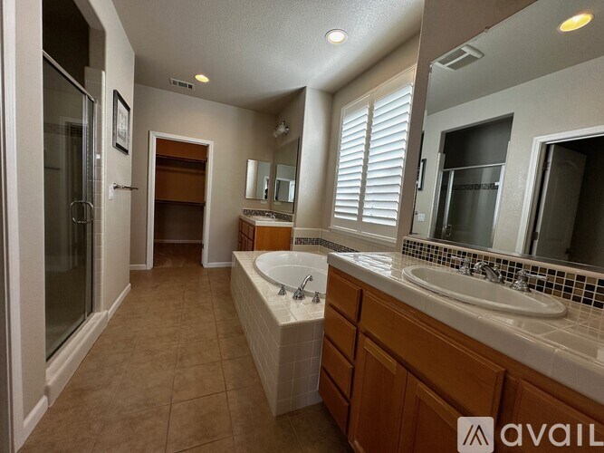 A bathroom with a sink, mirror, and a shower.