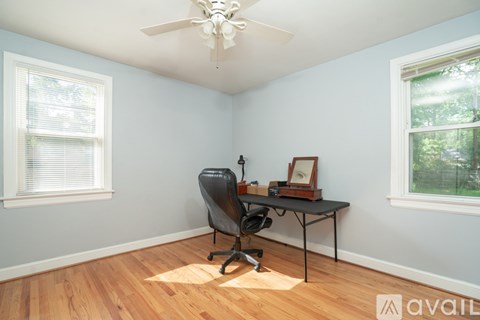 A bedroom with a bed, a television, and a ceiling fan.