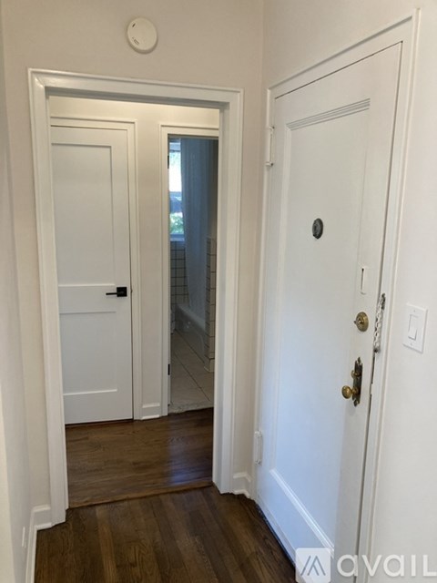 A white door with a gold handle is on the right.