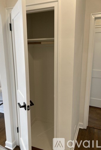 A white door with a black handle is open.