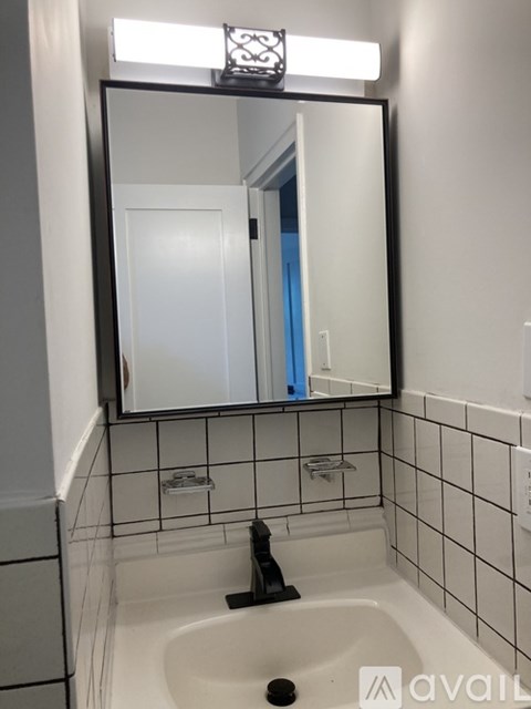 A bathroom with a white sink and a mirror above it.