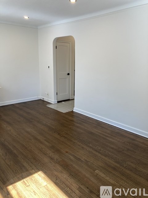 A room with a wooden floor and a white door.
