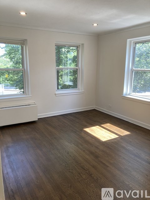 A room with wooden floors and two windows.