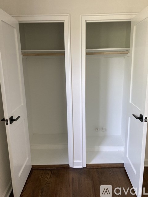 Two white closet doors with shelves and handles.