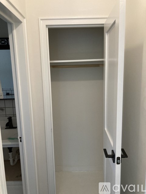 A white door with a black handle is open.