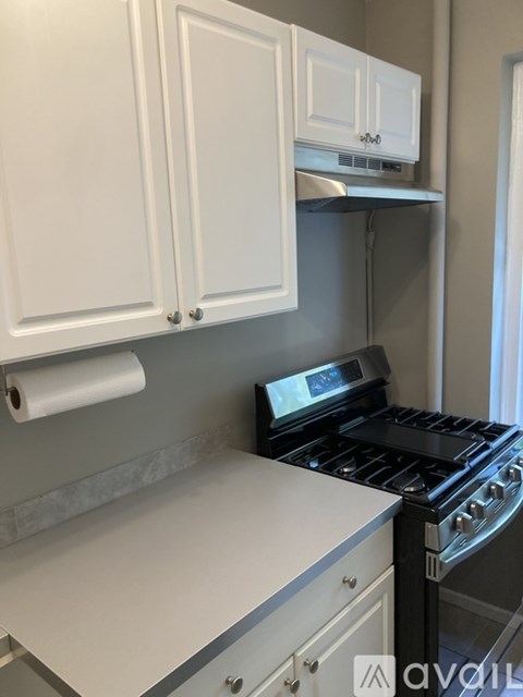 A kitchen with white cabinets and a black stove.