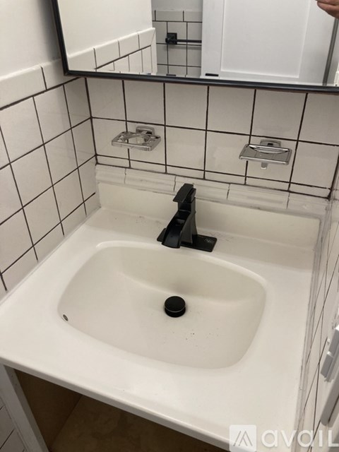 A white bathroom sink with a black faucet.