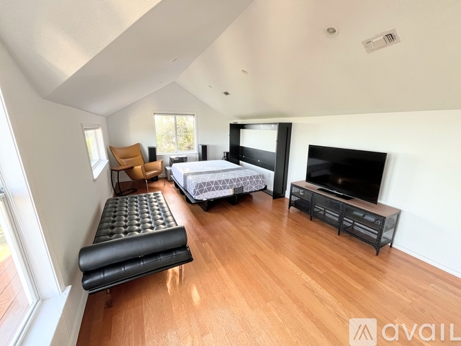 A bedroom with a bed, a bench, and a television.