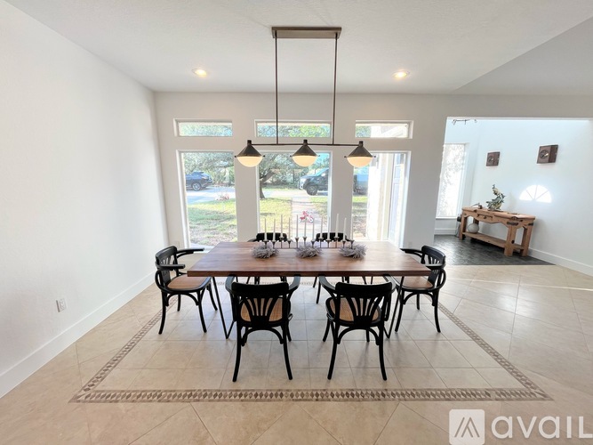 A dining room with a large table and chairs.