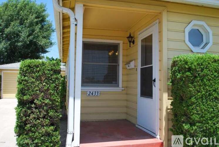 A yellow house with a white door and window.