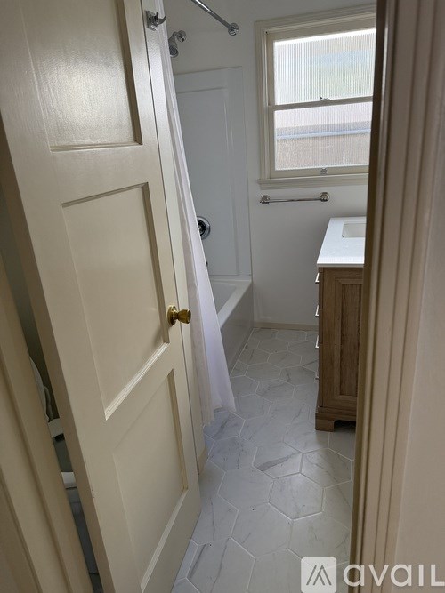 A bathroom with a toilet, sink, and window.