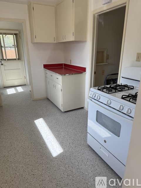 A kitchen with a white stove and a red counter.
