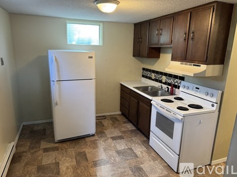 A kitchen with a white fridge and stove.
