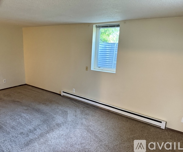 A room with a window and a wall-mounted air conditioner.