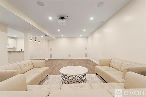 A spacious living room with a white sofa set and a coffee table.