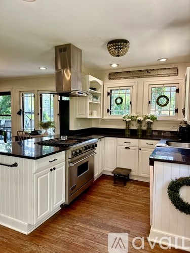 A kitchen with white cabinets and a black countertop.