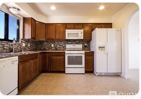 A kitchen with brown cabinets and white appliances.