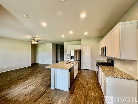 A kitchen with white cabinets and a wooden floor.