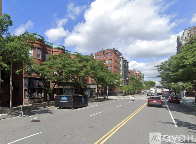 A street view with cars, trees, and buildings.