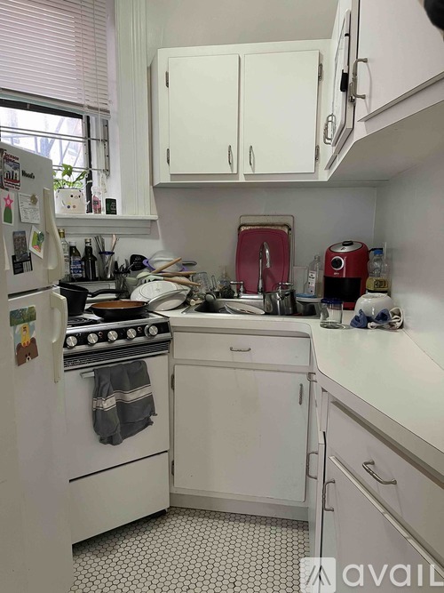A kitchen with white appliances and cabinets.