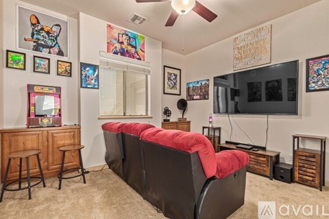 A living room with a red couch and a flat screen TV.