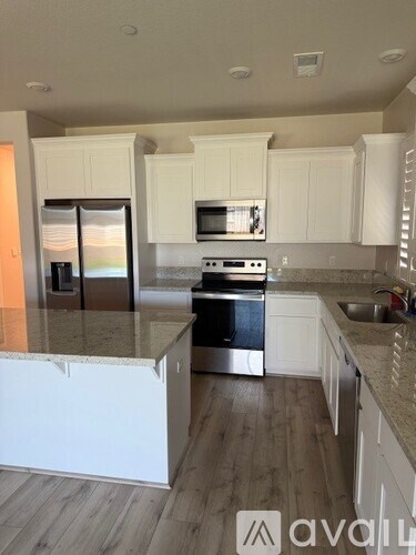 A kitchen with white cabinets and a granite countertop.
