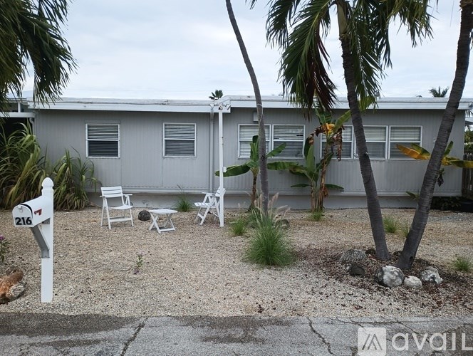 A house with a white fence and a mailbox number 216.