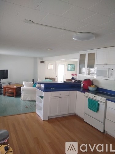 A kitchen with white cabinets and a blue counter.