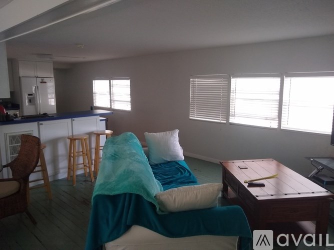 A living room with a couch covered in a blue blanket.