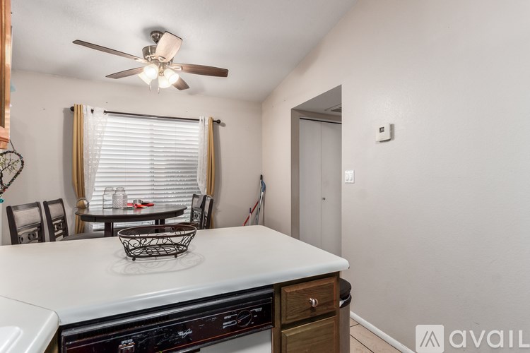 A kitchen with a white countertop and a ceiling fan.