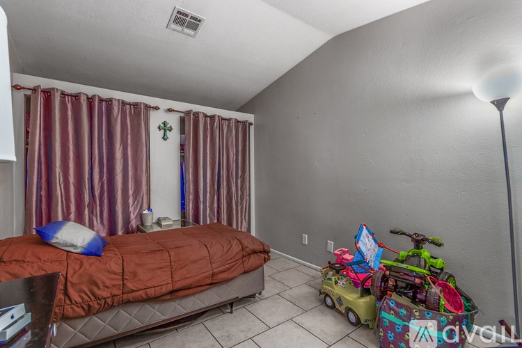 A bedroom with a bed, a chair, and a toy truck.
