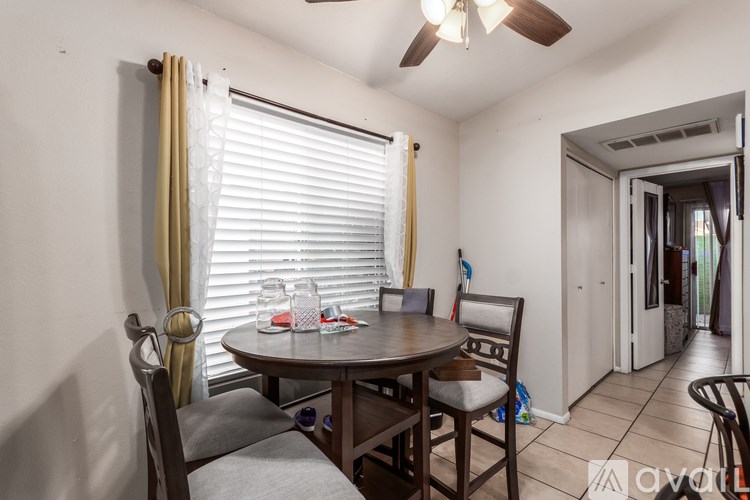 A dining room with a table and chairs.