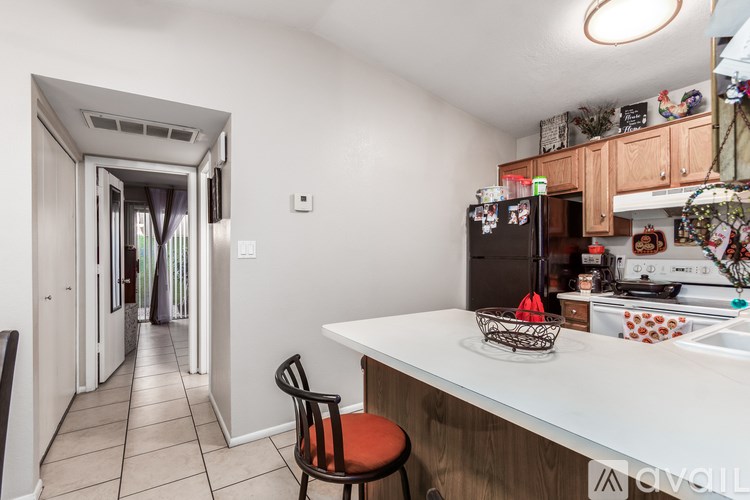 A kitchen with a white counter and a black chair.