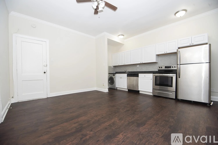 A kitchen with white cabinets and a stainless steel refrigerator.